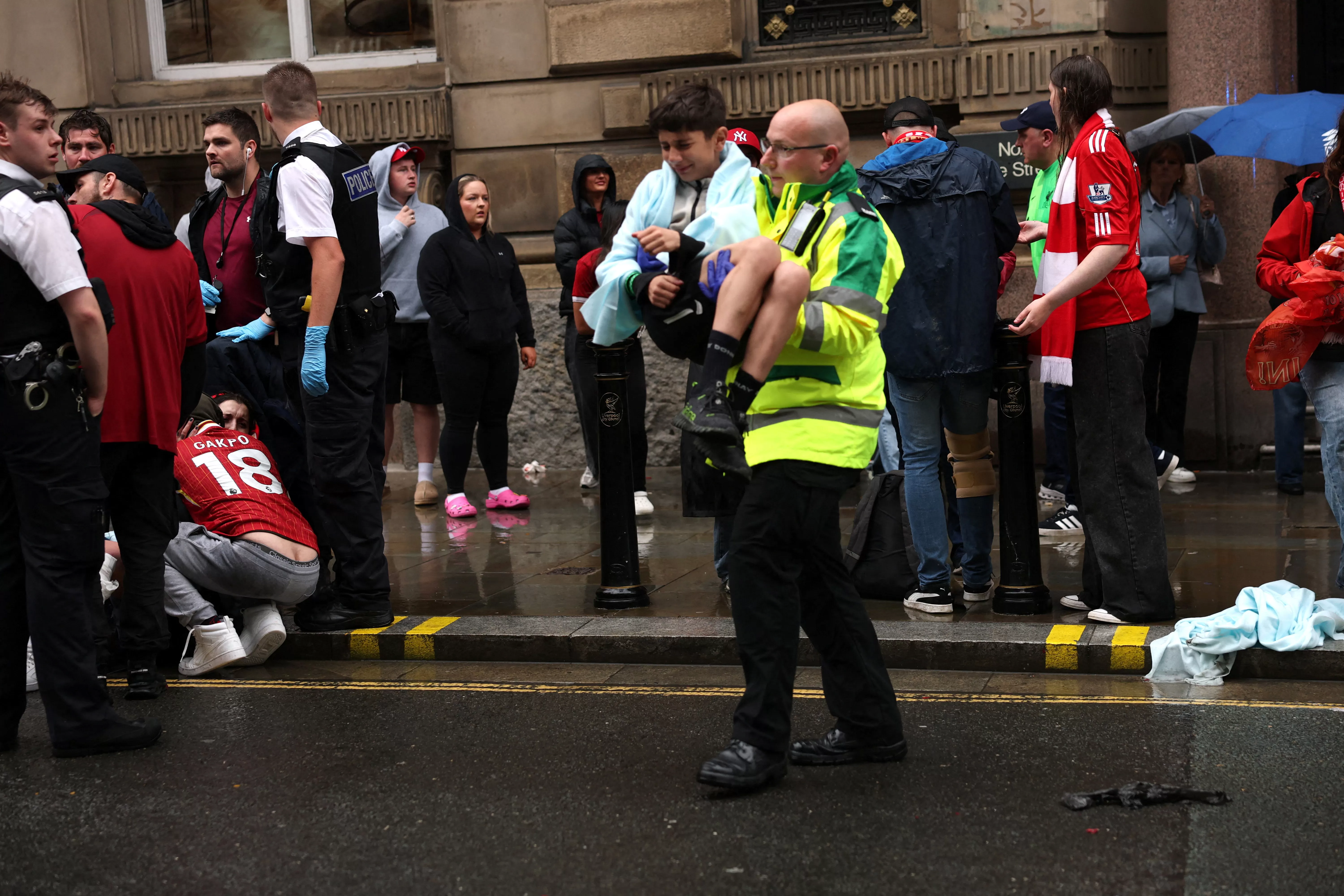 A paramedic carries a child after multiple people were hit by a car during the Victory parade