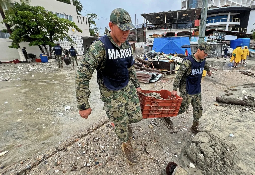 Mexican navy members assist with cleanup efforts in Puerto Escondido, Oaxaca after Hurricane Erick passed.