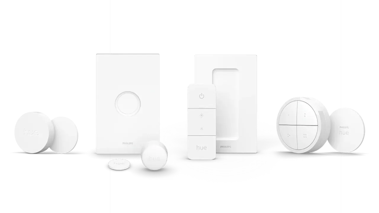 Comparison of Philips Hue smart switches including the new larger Smart Button, the original smaller Smart Button, the Dimmer Switch, and the Tap Dial switch