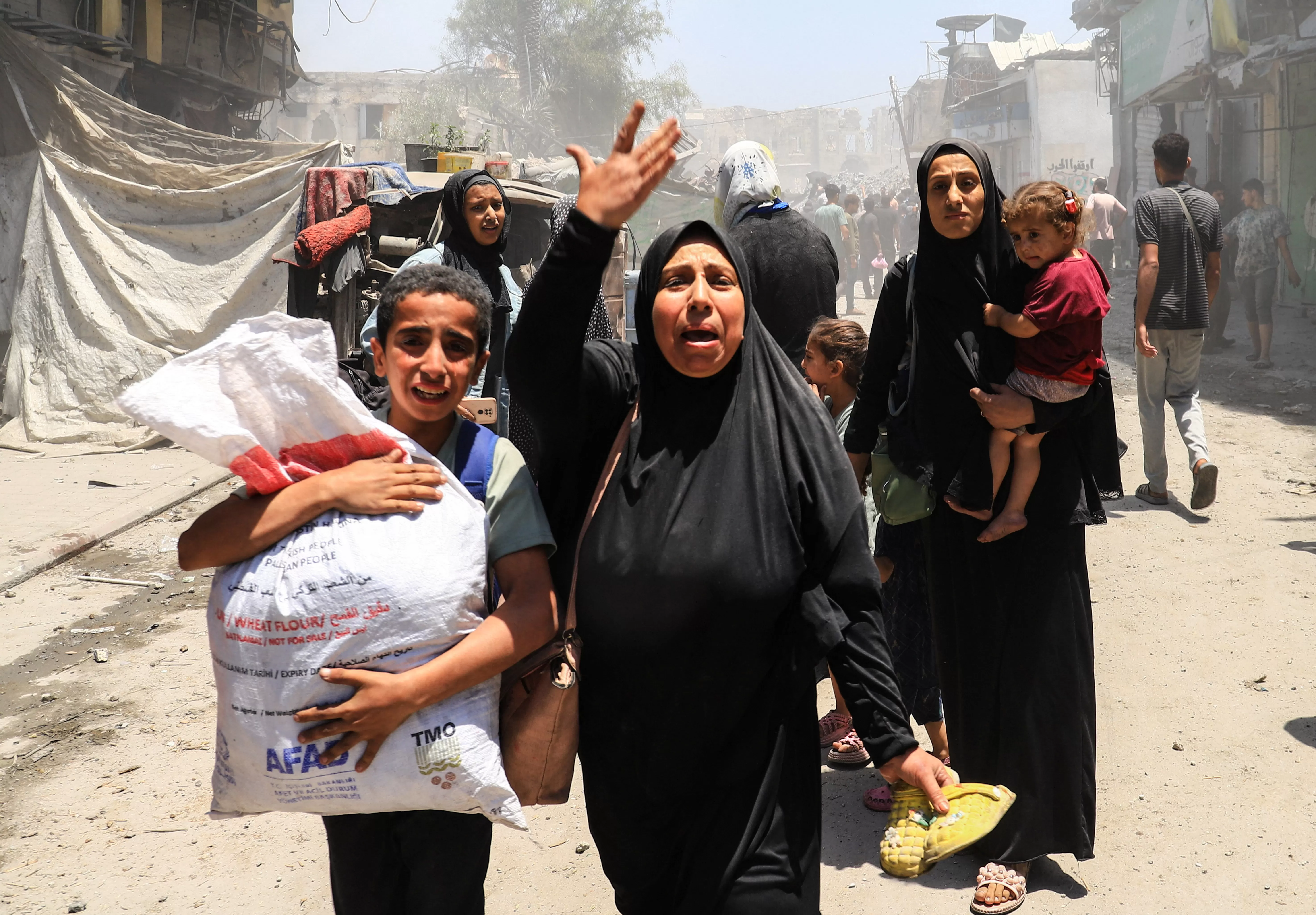 Palestinians evacuate in the aftermath of an Israeli attack on a house in Gaza City