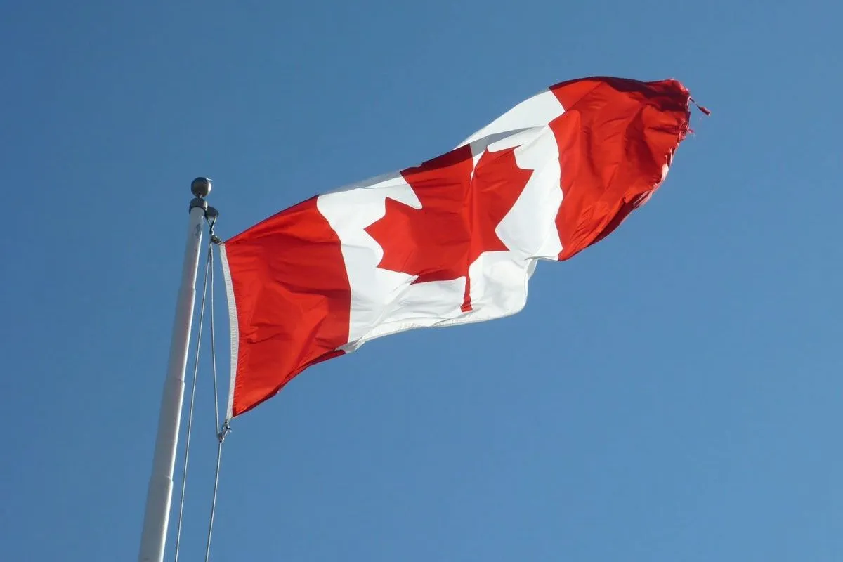 Canada flag flying against a blue sky