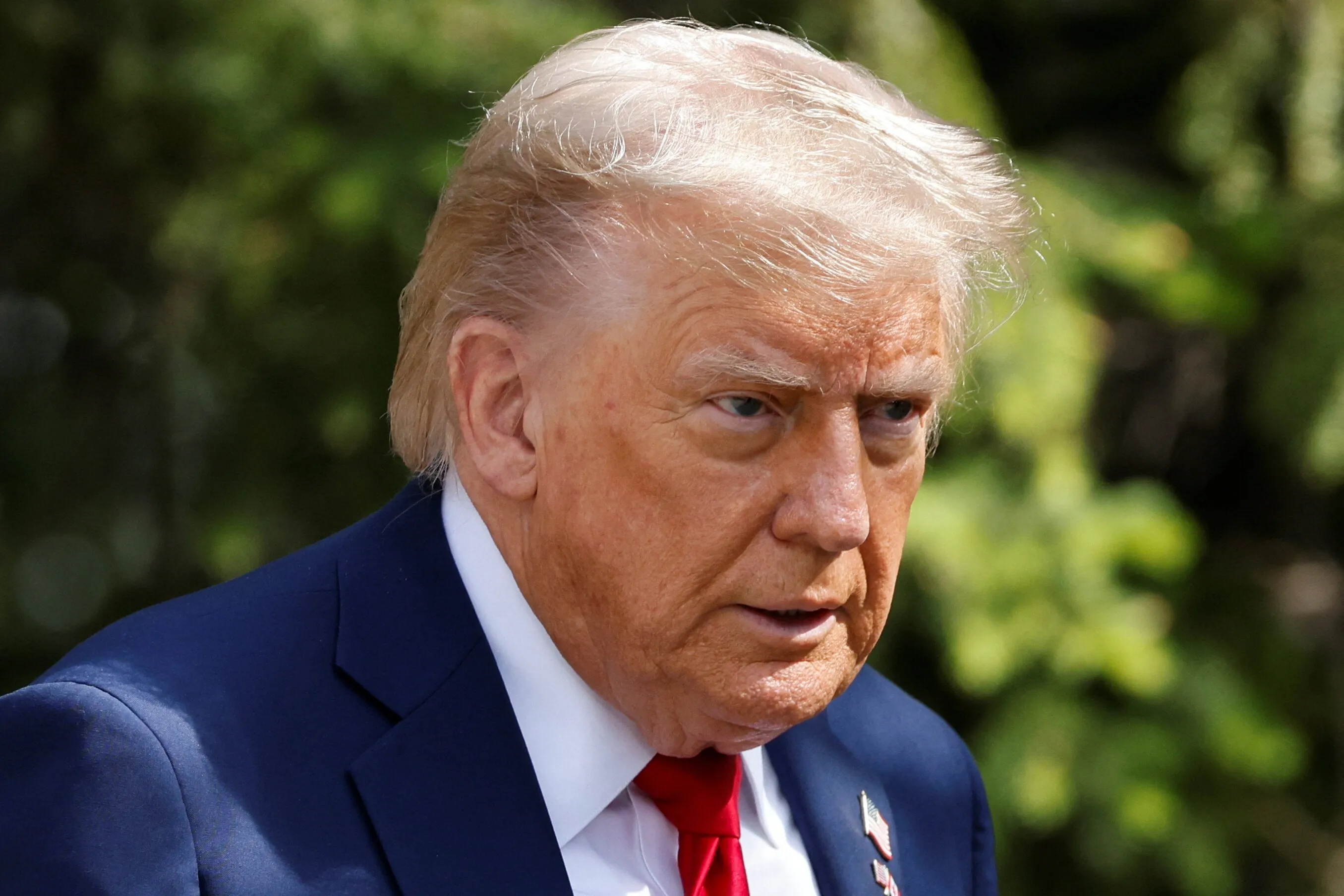 Donald Trump pictured, discussing the construction of new flagpoles amid rising international tensions.