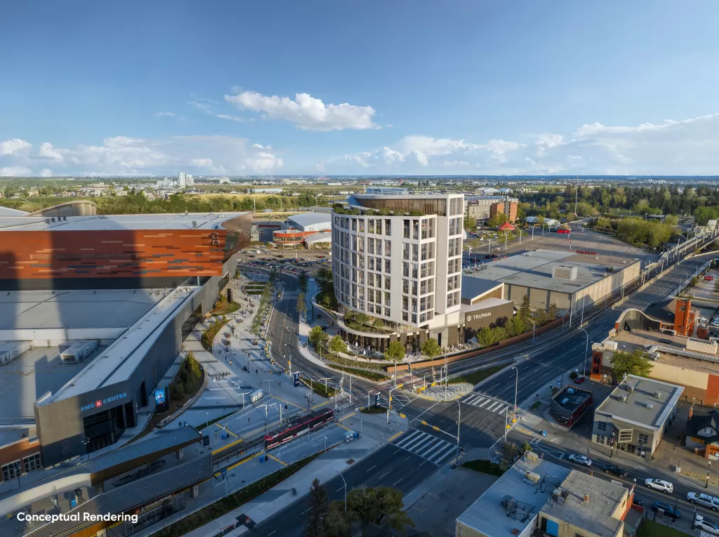 Conceptual rendering of a curved hotel building from an aerial perspective near a road intersection, showing the design planned for Calgary's Stampede Park