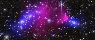 Composite image of the Bullet Cluster showing blue regions mapping dark matter and pink regions mapping hot gas against a backdrop of galaxies.